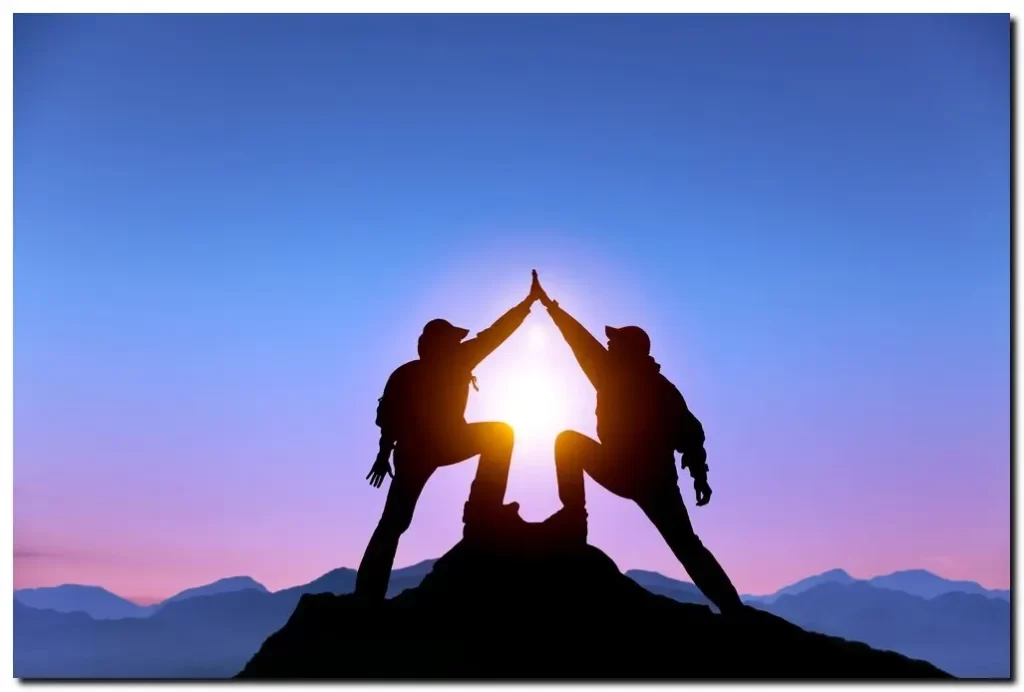 two men on a mountain top giving high five