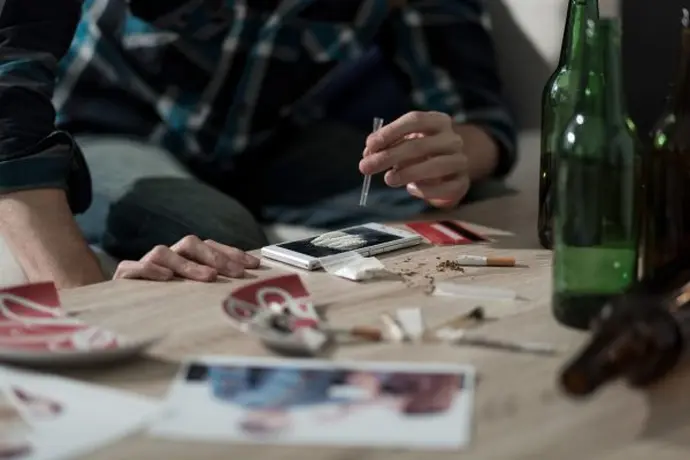 Man addicted to using coke to get high doing a line of cocaine.